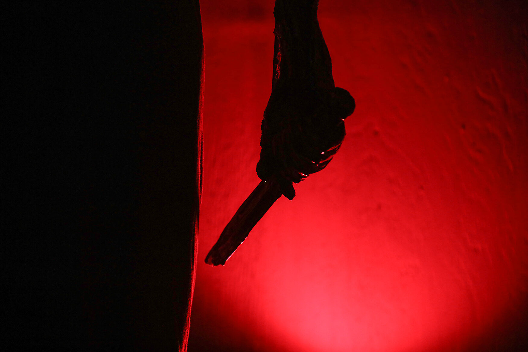 Light illuminates the hand of a mannequin holding a knife inside The Necropolis